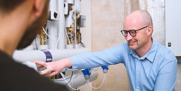 Studerende arbejder koncentreret med deres projekter i et moderne undervisningsmiljø med bærbare computere og samarbejde